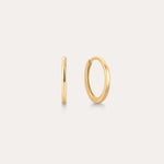 The 14K Recycled Solid Gold Plain Huggie Earring is shown on a light background, with one earring displayed from the side and the other highlighting its classic circular shape.