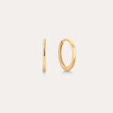 The 14K Recycled Solid Gold Plain Huggie Earring is shown on a light background, with one earring displayed from the side and the other highlighting its classic circular shape.