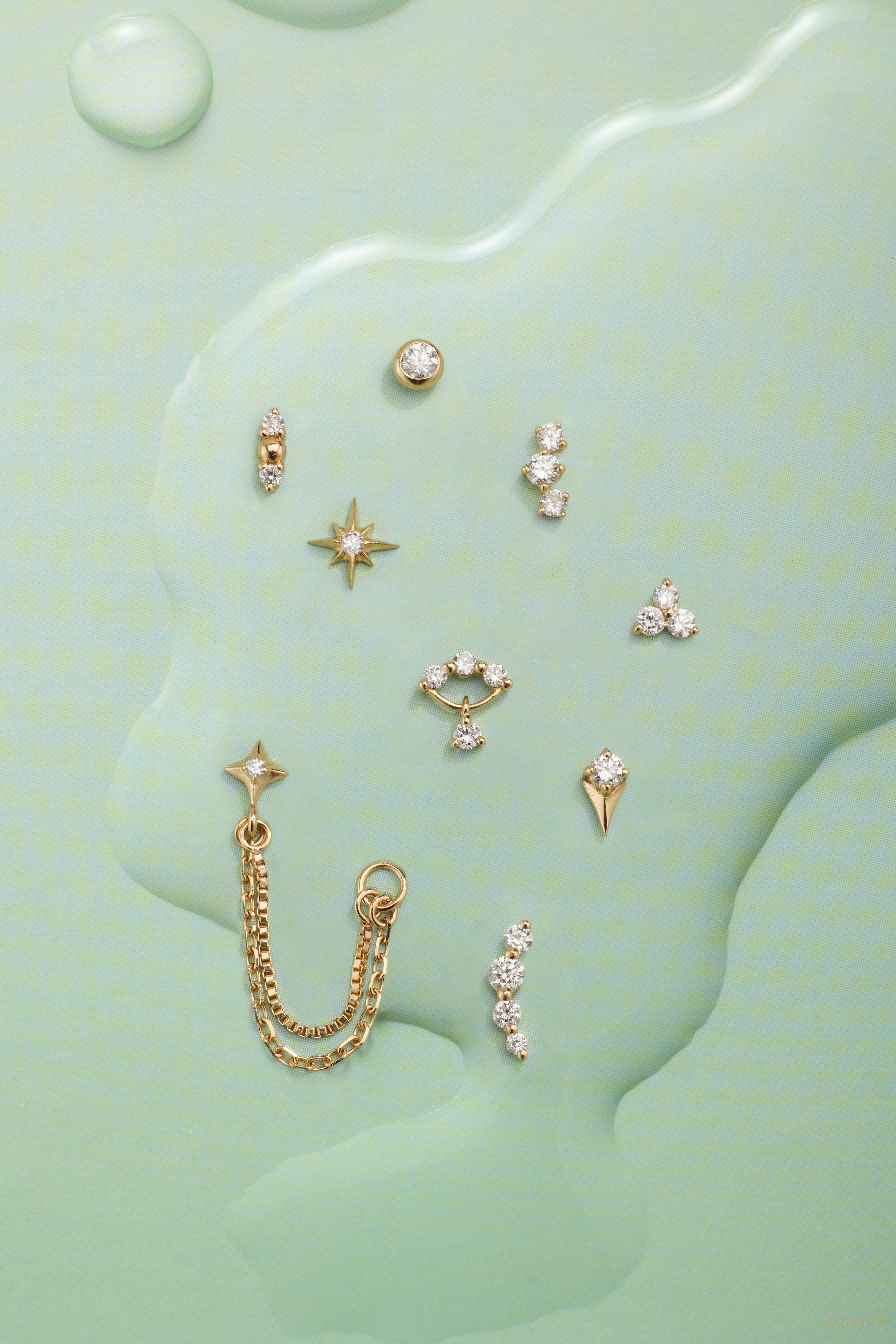 Collection of gold earrings on a green textured background