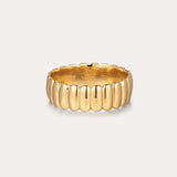 The Charlotte Eternity Ridged Ring in Gold features a scalloped, ribbed design encircling the band, elegantly displayed against a plain, light background.
