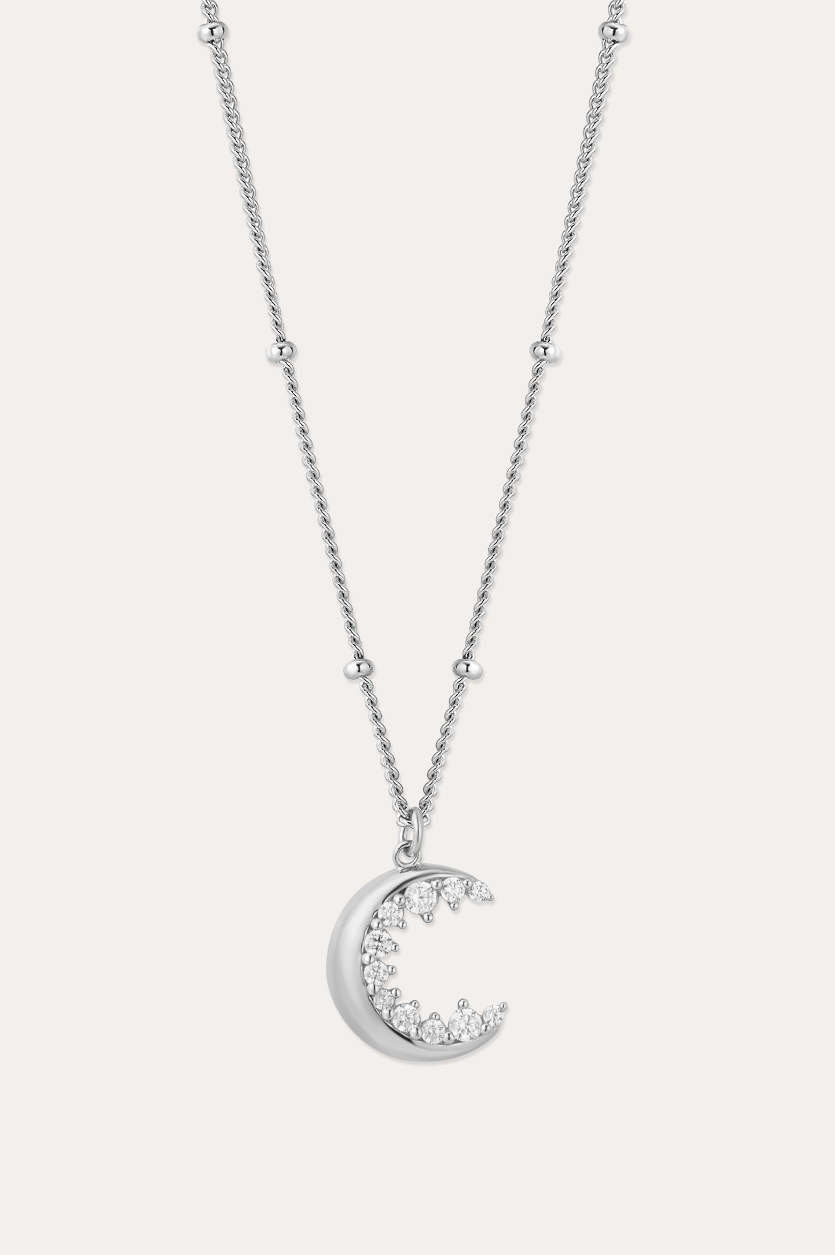 The Crescent Moon Crystal Charm Beaded Necklace in Silver features a delicate beaded chain and a crescent moon pendant adorned with sparkling clear stones.