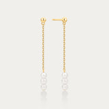 Gold chain earrings with pearls on a light gray background