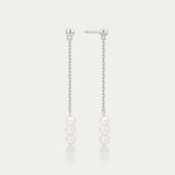 Pair of pearl drop earrings on a light gray background