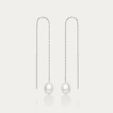 The Eira Pearl Drop Threader Earrings in Silver feature elegant thin chains with a single white pearl at each end, shown on a plain white background.