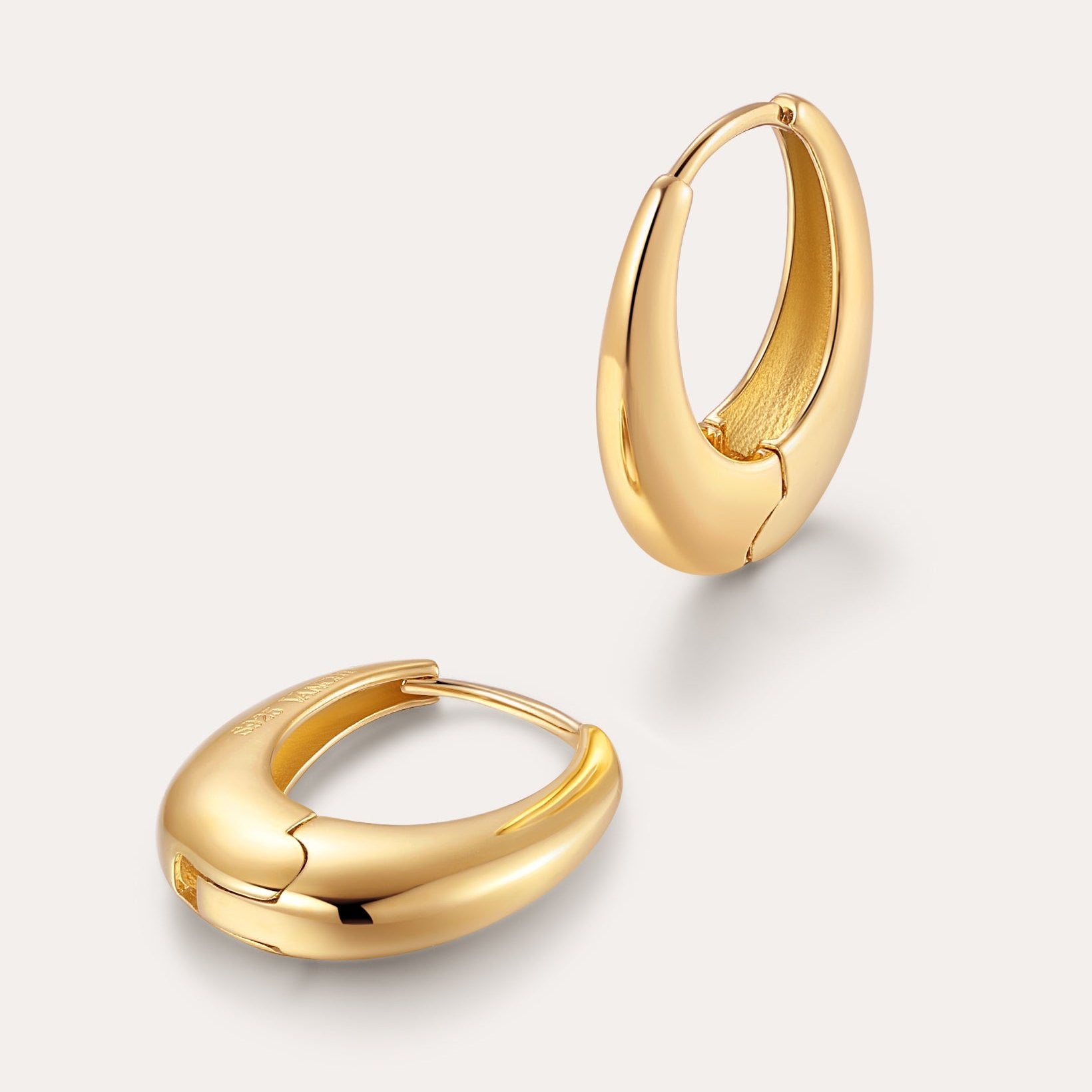 The Lila Medium Round Dome Hoop Earrings in 18k gold plated feature a shiny, smooth, chunky design and are displayed on a light background.