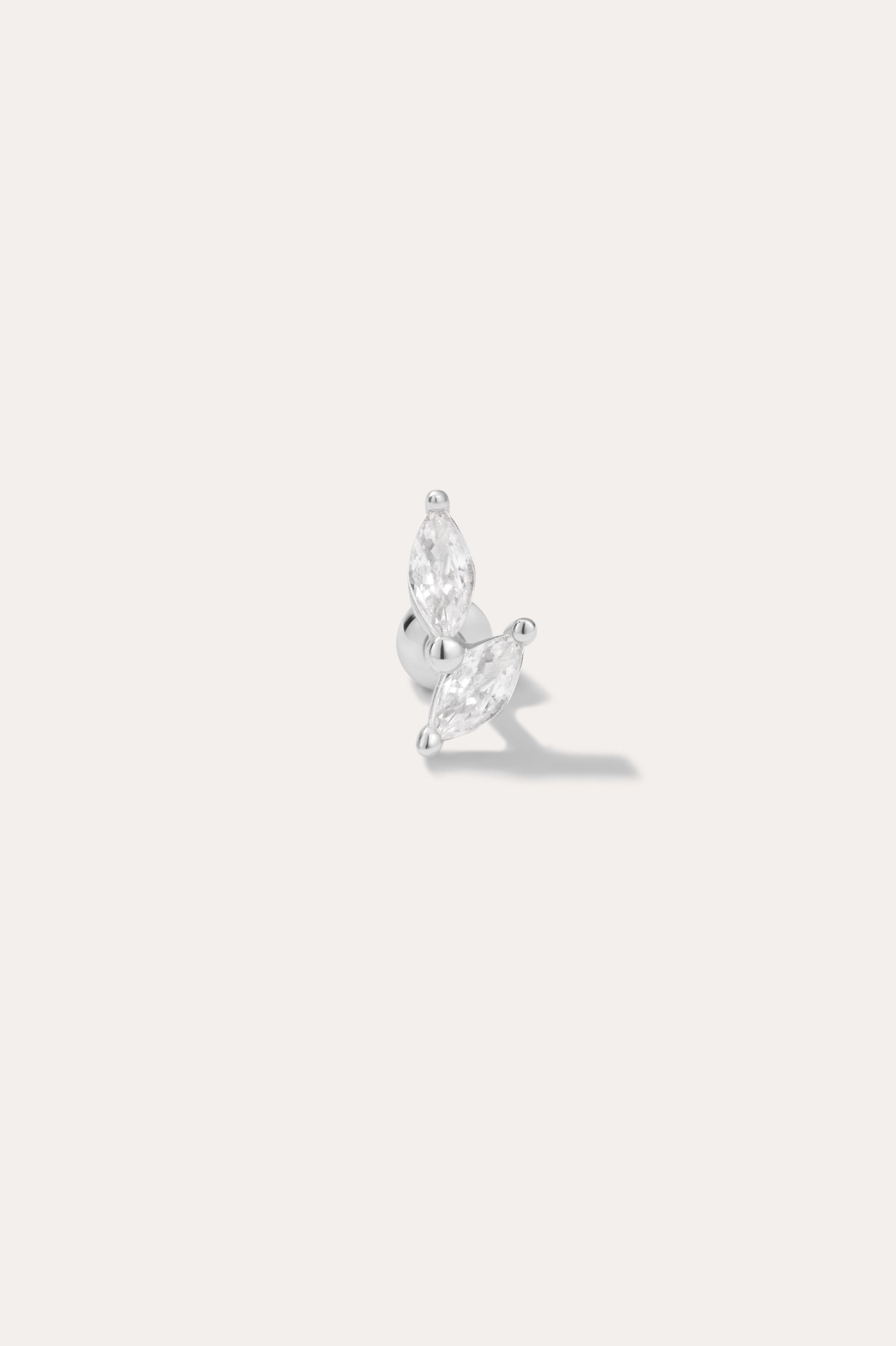 The Flora Barbell Stud in Silver features two marquise-cut clear gemstones set at an angle, shown against a plain light background.