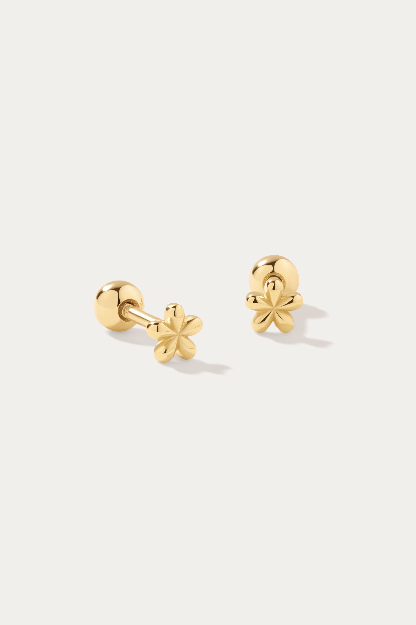 The Fleur Flower Barbell Stud Piercing in Gold features small, six-petal floral studs, ideal for ear stacking and shown on a simple white background.
