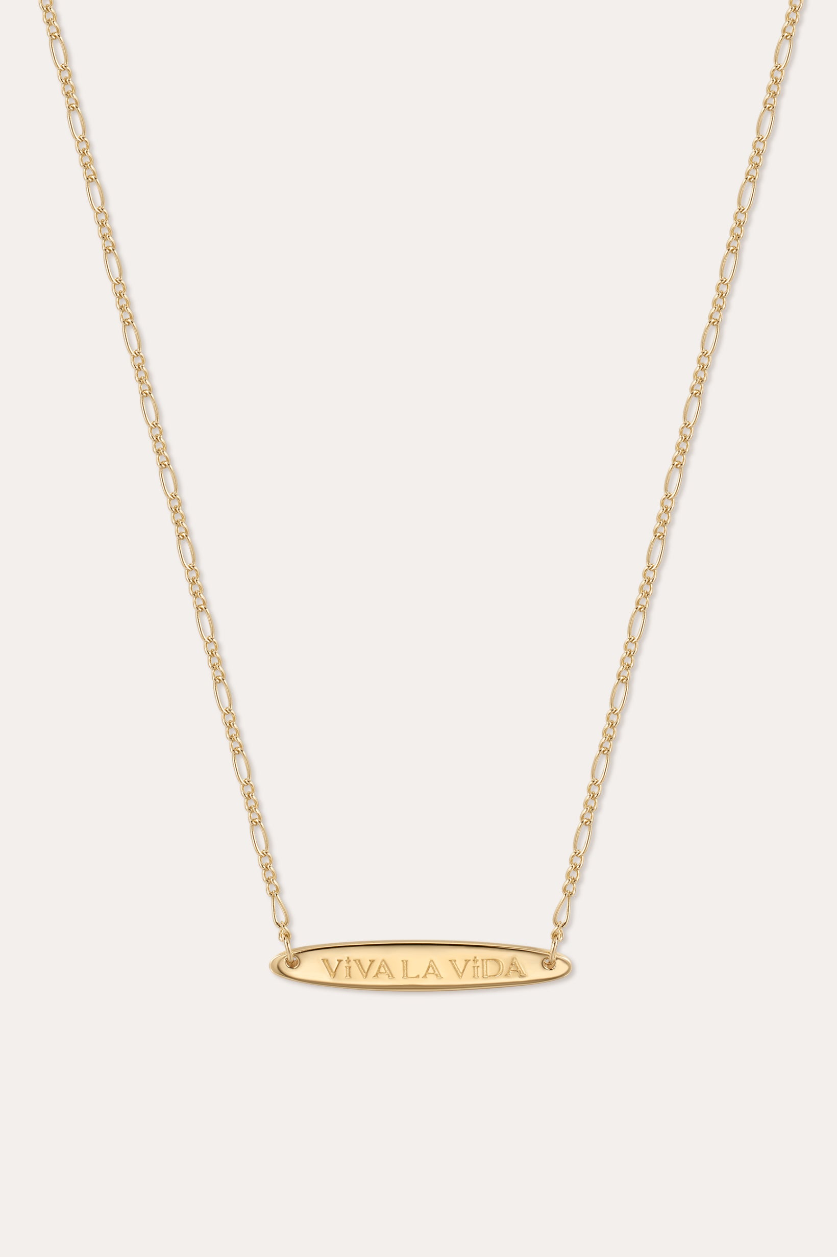 The Viva La Vida Bar Chain Necklace in Gold features an oval horizontal pendant engraved with VIVA LA VIDA on an adjustable delicate figaro chain for the perfect fit.