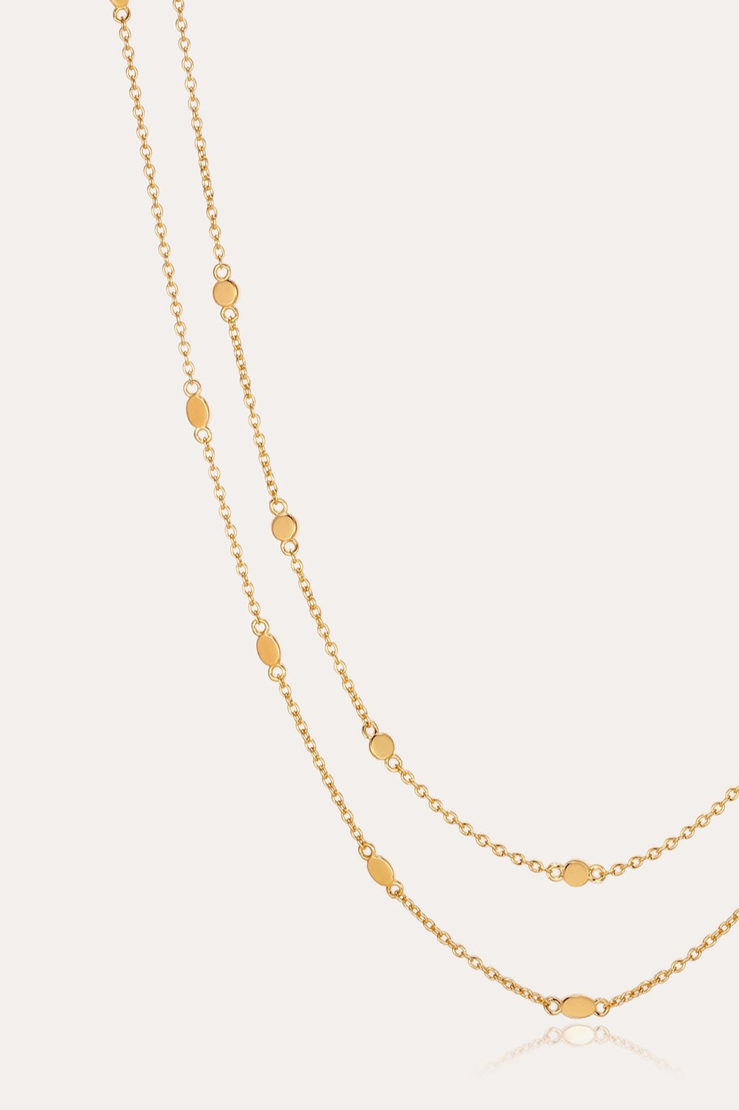 The Simona Double Chain Stacking Necklace in Gold features delicate oval-shaped accents spaced evenly along its length, ideal for stacking or layering, and is shown against a simple, light background.