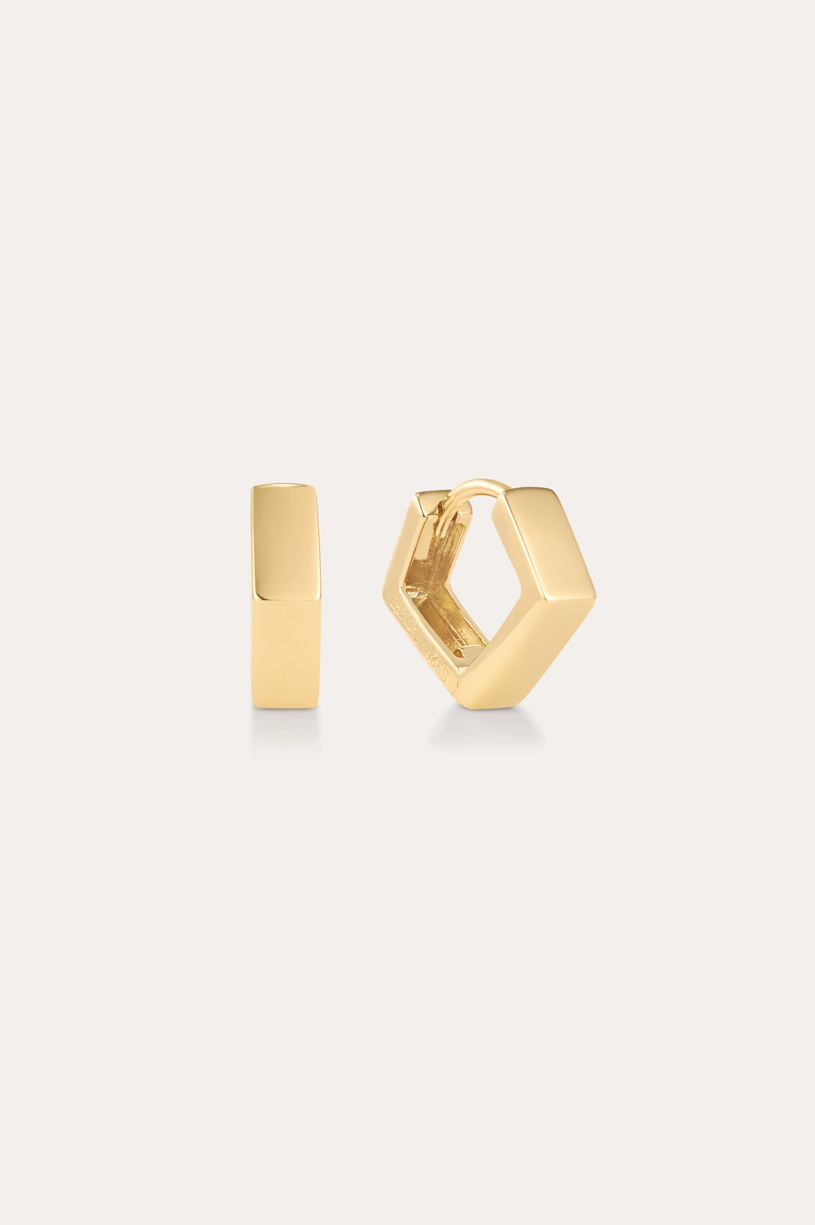 The Judith Hexagon Angular Huggies in Gold are 18k gold plated hoop earrings with a modern, angular design, shown against a light background—one earring is front-facing, the other highlights its side profile and clasp.