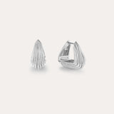 The Juno Ridged Chunky Hoops in Silver, featuring a modern fan-like ridged pattern, are showcased against a plain light background, with one earring closed and the other open to highlight the clasp design.