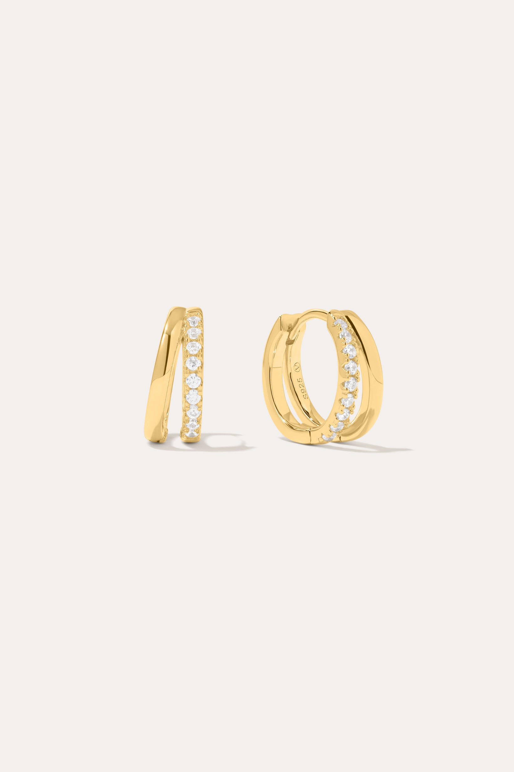 Kira Crystal Double Hoop Huggies in 18k Gold Plated, featuring a row of clear round crystals along the front, are displayed against a plain off-white background.
