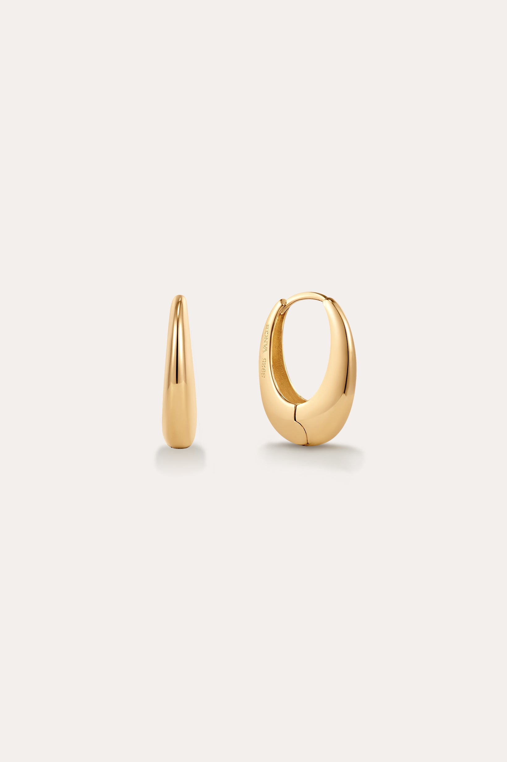The Lila Medium Round Dome Hoop Earrings in Gold, each 16mm and crafted in 18k yellow gold, are displayed on a plain light background—one showing its sleek side curve, the other highlighting its polished, rounded front.