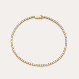 The Lumi Tennis Bracelet in Gold features small, closely set cubic zirconia along its length and a rectangular clasp engraved with VANCHI, beautifully displayed on a simple, light background.