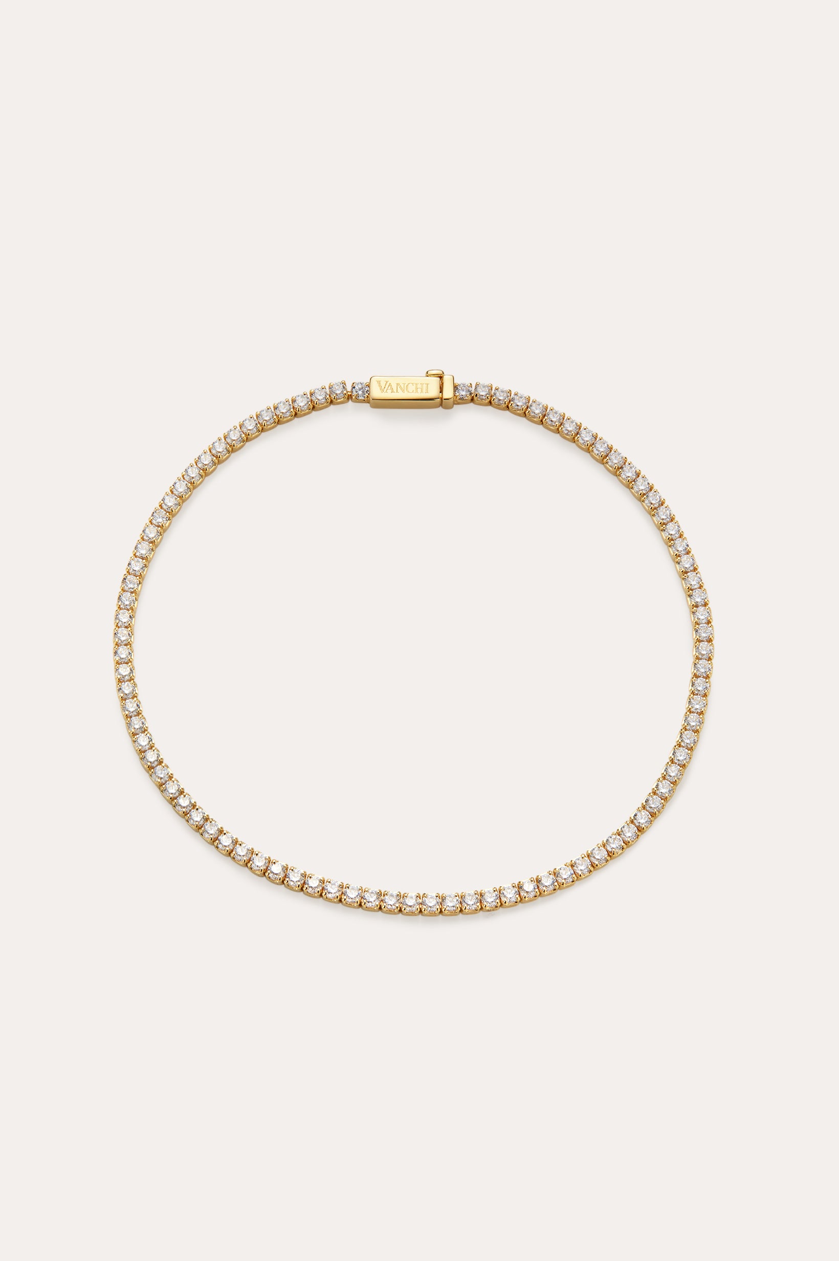 The Lumi Tennis Bracelet in Gold features small, closely set cubic zirconia along its length and a rectangular clasp engraved with VANCHI, beautifully displayed on a simple, light background.