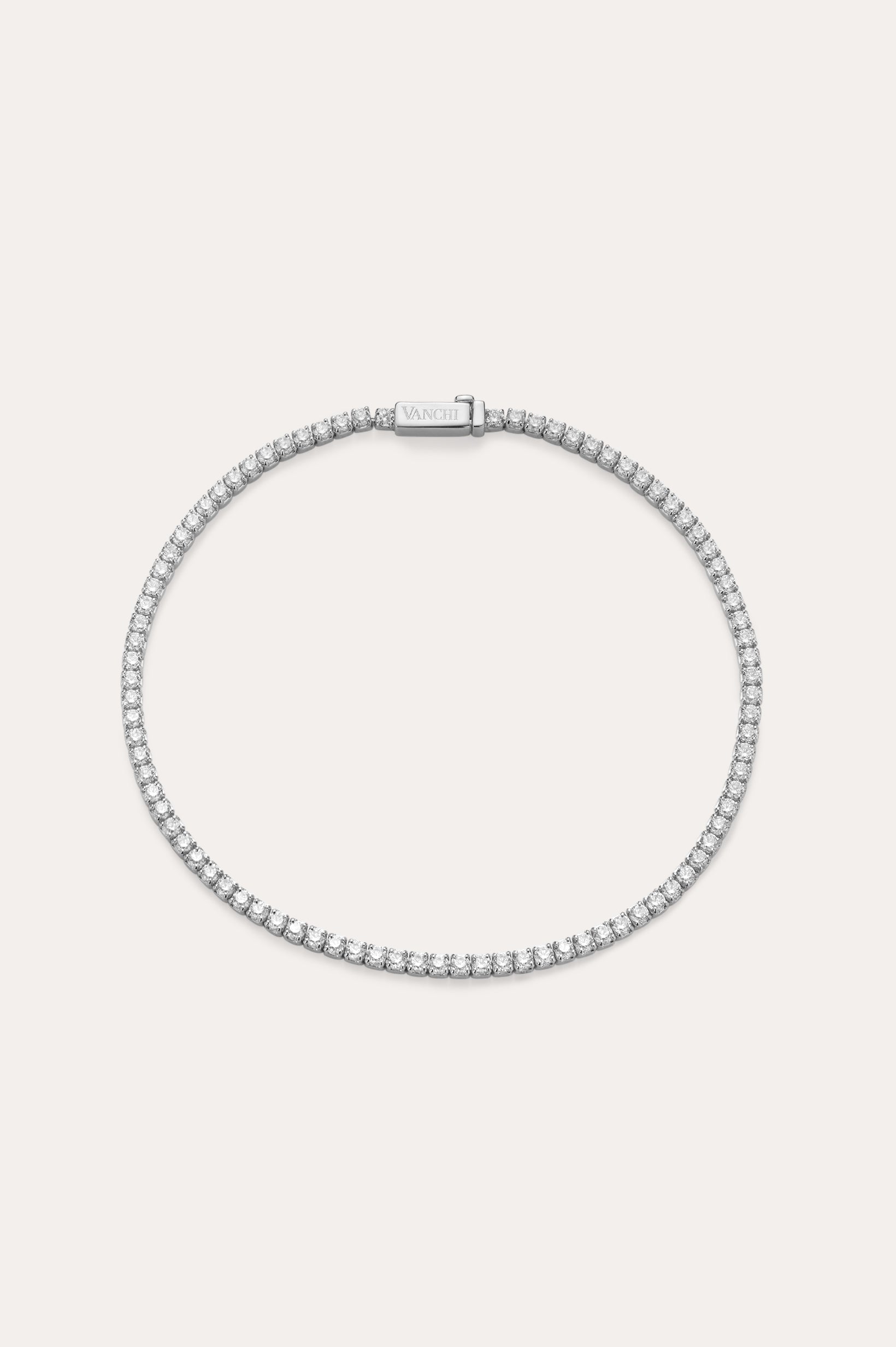 The Lumi Tennis Bracelet in Silver features a single row of sparkling cubic zirconia on a slim sterling silver band with a rectangular clasp, elegantly displayed against a plain, light background.