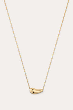 Gold necklace with a small pendant on a light gray background