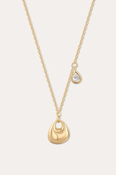 The Nora Double Pendant Necklace in Gold features a smooth sculptural pendant and a delicate teardrop charm with clear cubic zirconia, displayed on a plain light background.