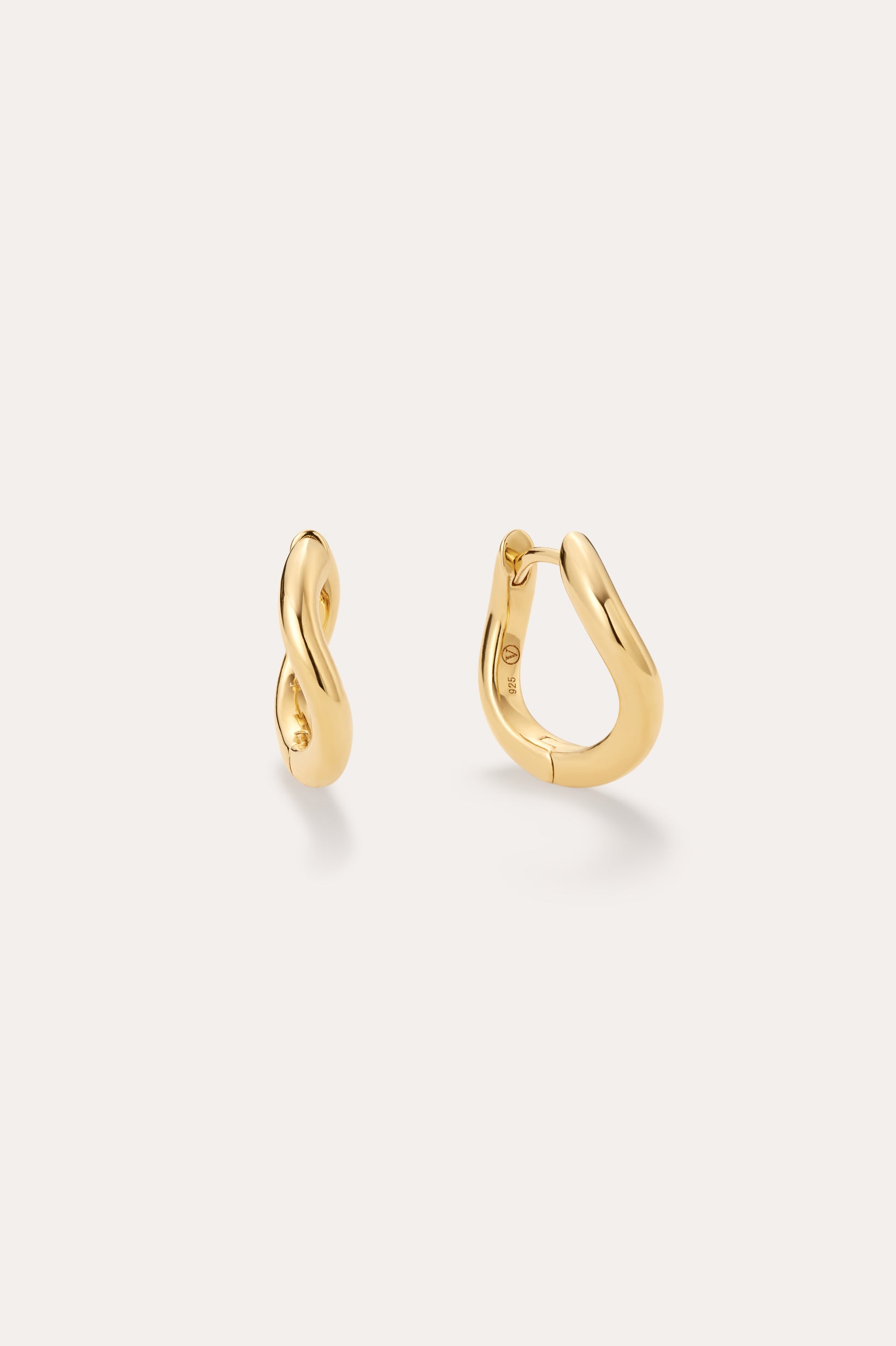 The Nori Twisted Hoop Earrings in Gold, featuring an 18k gold-plated, organically twisted design, are displayed on a plain light background—one shown from the front and one from the side to highlight their fluid curves.
