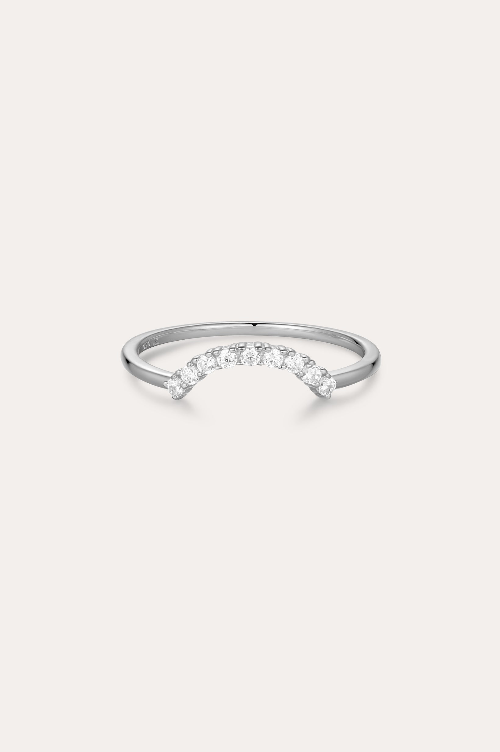 The Reine Rainbow Crystal Ring in Silver is a delicate sterling silver ring with a gentle curve, featuring a row of small, sparkling rainbow crystals set along the curved band. Its thin, minimalist design adds elegant color to any look.