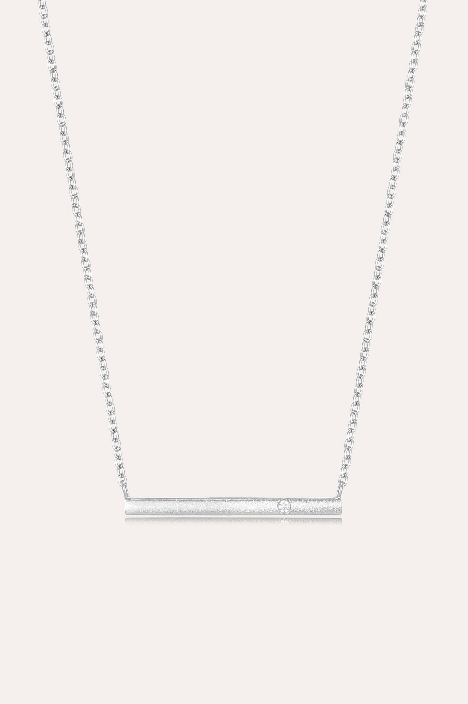The Regina Horizontal Bar Pendant Necklace in Silver features a minimalist silver bar with a single, sparkling cubic zirconia at its center—ideal for lovers of simple, elegant jewelry.