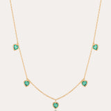 Thea Green Heart Pendant Gold Necklace features five small green cubic zirconia hearts evenly spaced on an adjustable gold chain, shown against a plain light background.