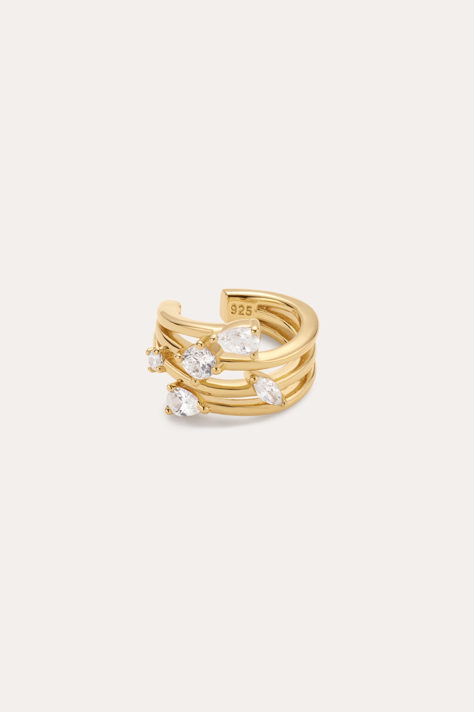 The Vale Crystal Ear Cuff in Gold features three parallel gold bands with clear gemstones and a “925” stamp inside, indicating sterling silver beneath the gold finish. Perfect for adding sparkle to your ear stack.