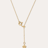 Gold necklace with a unique pendant on a light beige background