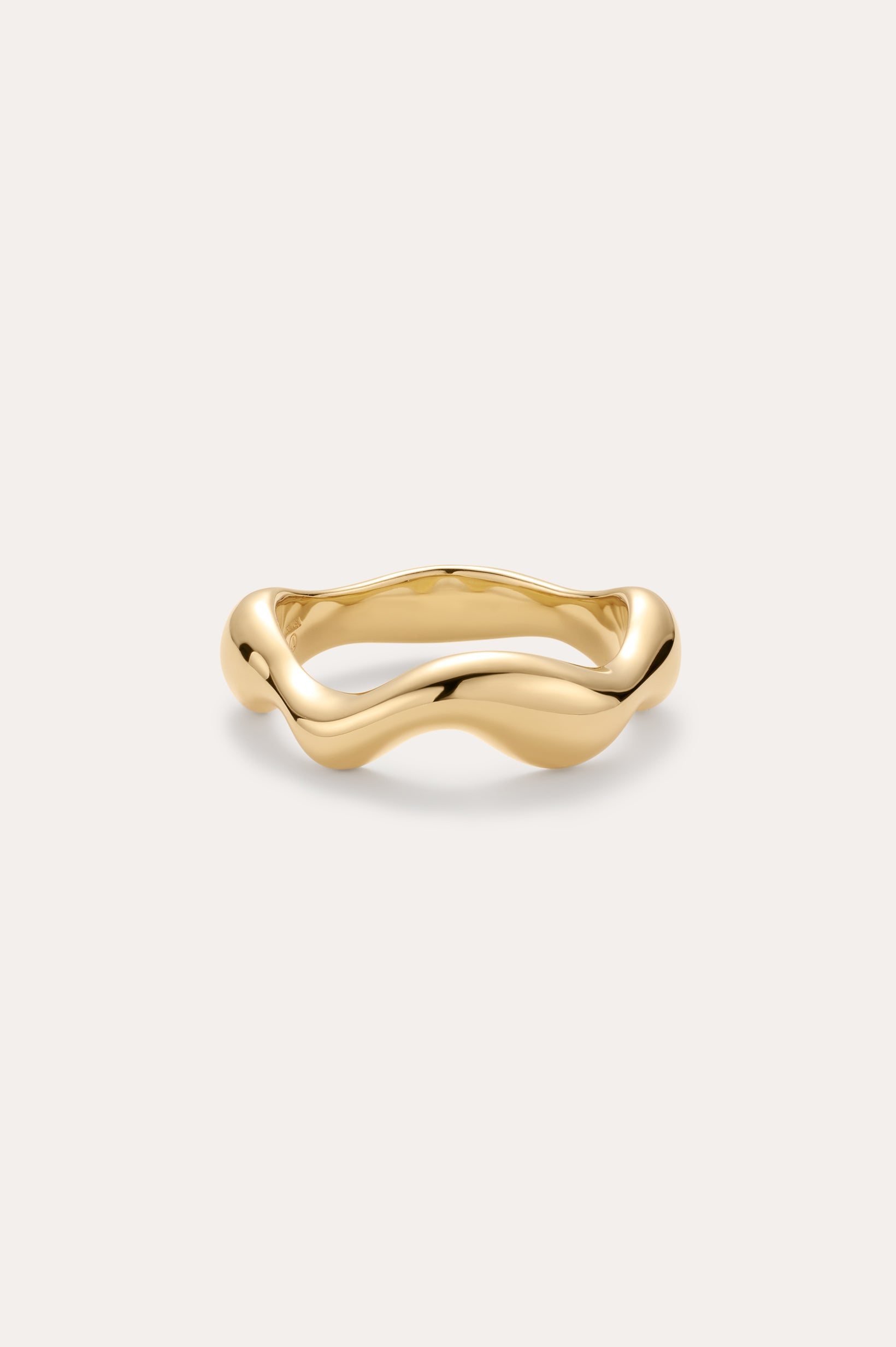 The Vica Fluid Wave Chunky Band Ring in Gold features a bold, wavy band design and is displayed on a simple, light background.