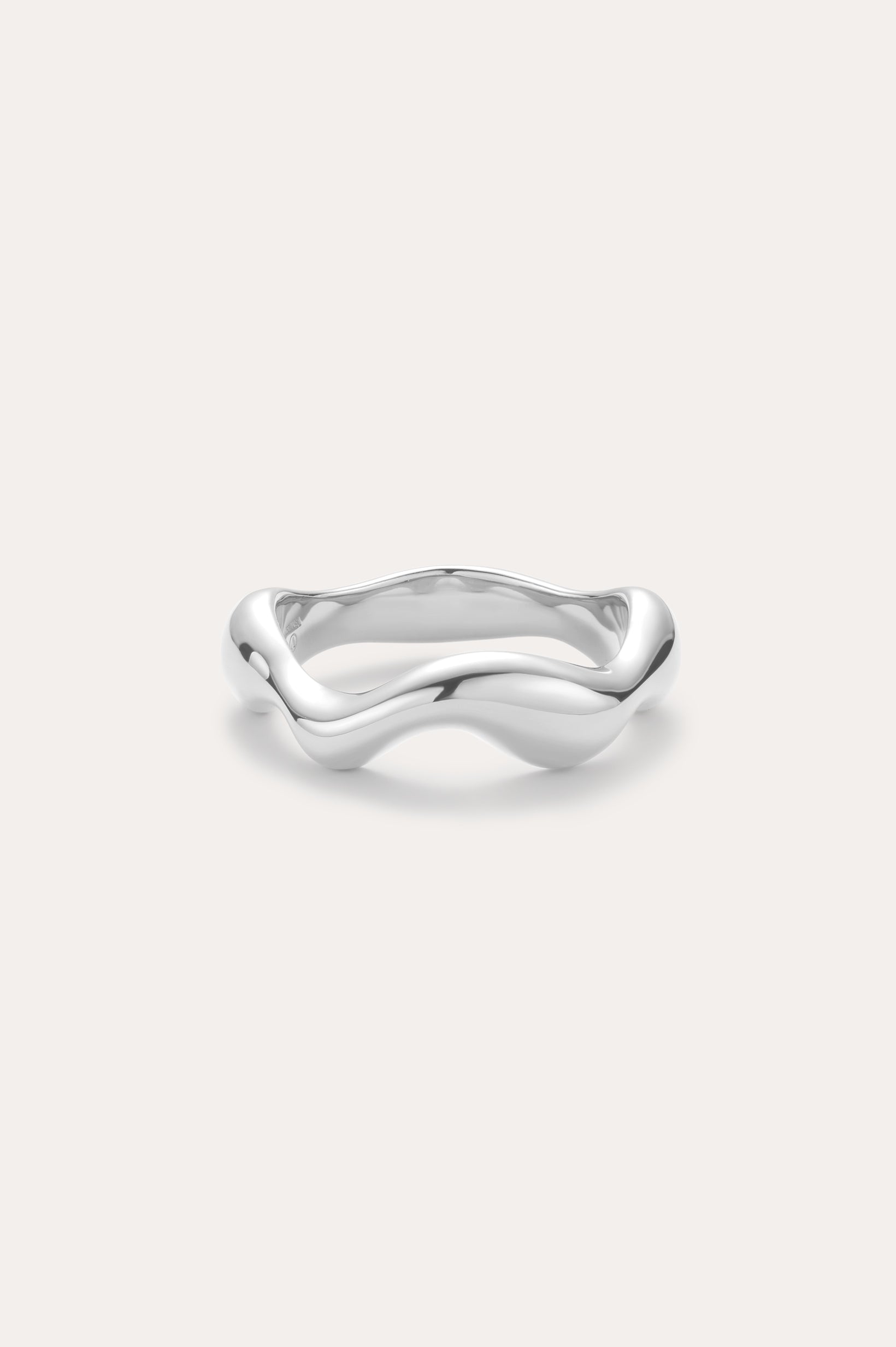 The Vica Fluid Wave Chunky Band Ring in Silver, featuring a smooth, wavy design, is displayed against a plain light background.