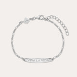 The Viva La Vida Bar Chain Bracelet in Silver features an adjustable Figaro chain, a rectangular plate engraved with VIVA LA VIDA, and a small embossed logo tag. Pair it with our Viva La Vida necklace for a matching set.