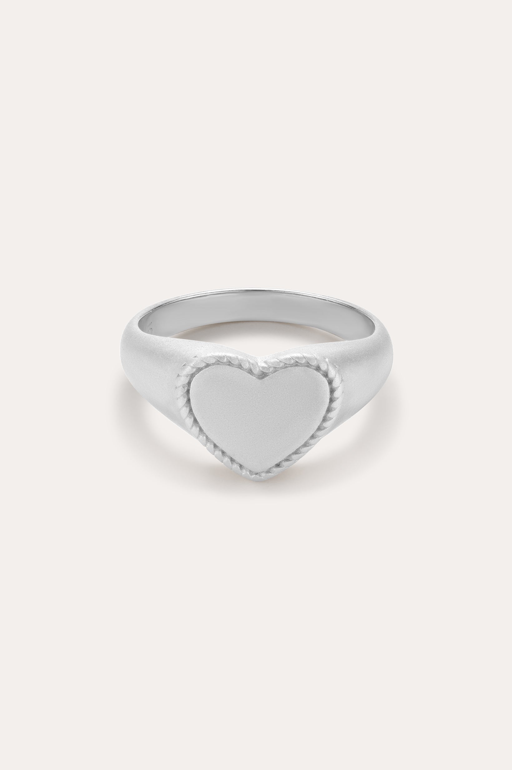 The Willa Heart Signet Pinky Ring in Silver features a smooth, heart-shaped face with a delicate textured border—ideal as a sterling silver pinky ring and beautifully presented on a plain light background.