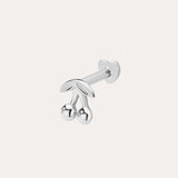 The 14K Solid White Gold Cherry Flat Back Stud, featuring two round cherry fruits and delicate leaves, stands out as elegant body jewelry against a plain light background.