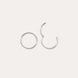 Two 14K Solid White Gold 20G Mini Clicker hoops are displayed on a plain white background—one closed, one slightly open—highlighting their simple, elegant circular design suitable for use as a nose ring or subtle ear accessory.