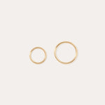 The 14K Solid Yellow Gold 20G Mini Clicker hoops, shown in two sizes on a plain white background, are perfect for classic cartilage wear or as minimalist hoop earrings.