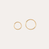 The 14K Solid Yellow Gold 20G Mini Clicker hoops, shown in two sizes on a plain white background, are perfect for classic cartilage wear or as minimalist hoop earrings.