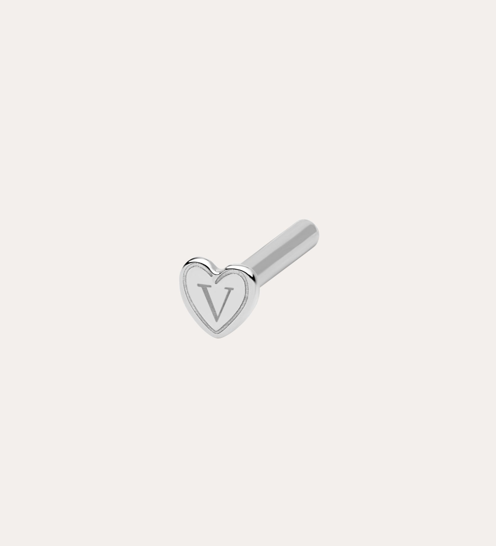 A small silver 18G(1mm) / 8mm Flat Back Post earring with a heart-shaped front engraved with "V," designed for comfort and shown against a plain light background.