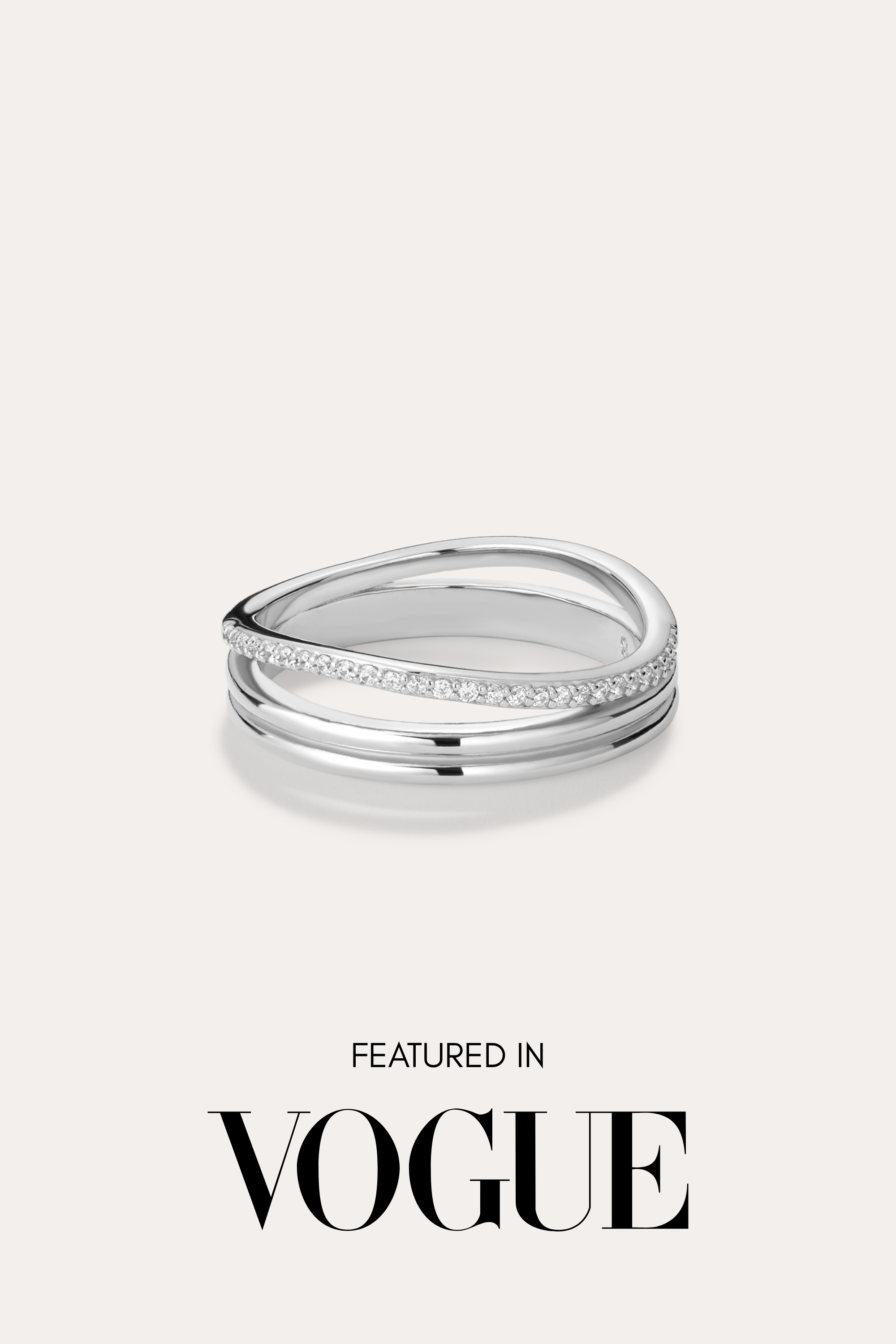 The Noor Pavé Triple Band Ring in Silver, featuring a modern curved design and a row of pavé diamonds, sits centered on a light background. Below the ring, black text reads FEATURED IN VOGUE.