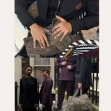 A collage shows two men in dark suits—one black, one burgundy—each with a taupe chain-strap bag. Close-ups spotlight the Vica Fluid Wave Chunky Band Ring in Silver among their accessories. Text: “Spotted On: Wolf & Badger Trending.”.