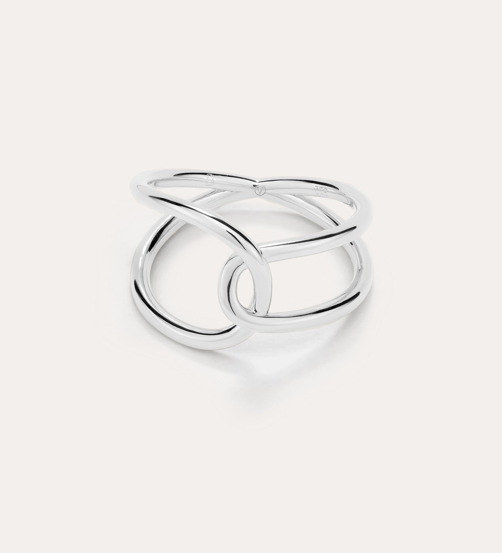 The Ayla Link Ring in Silver showcases a minimalist, modern design with two smooth, interlocking loops, set against a plain light background.
