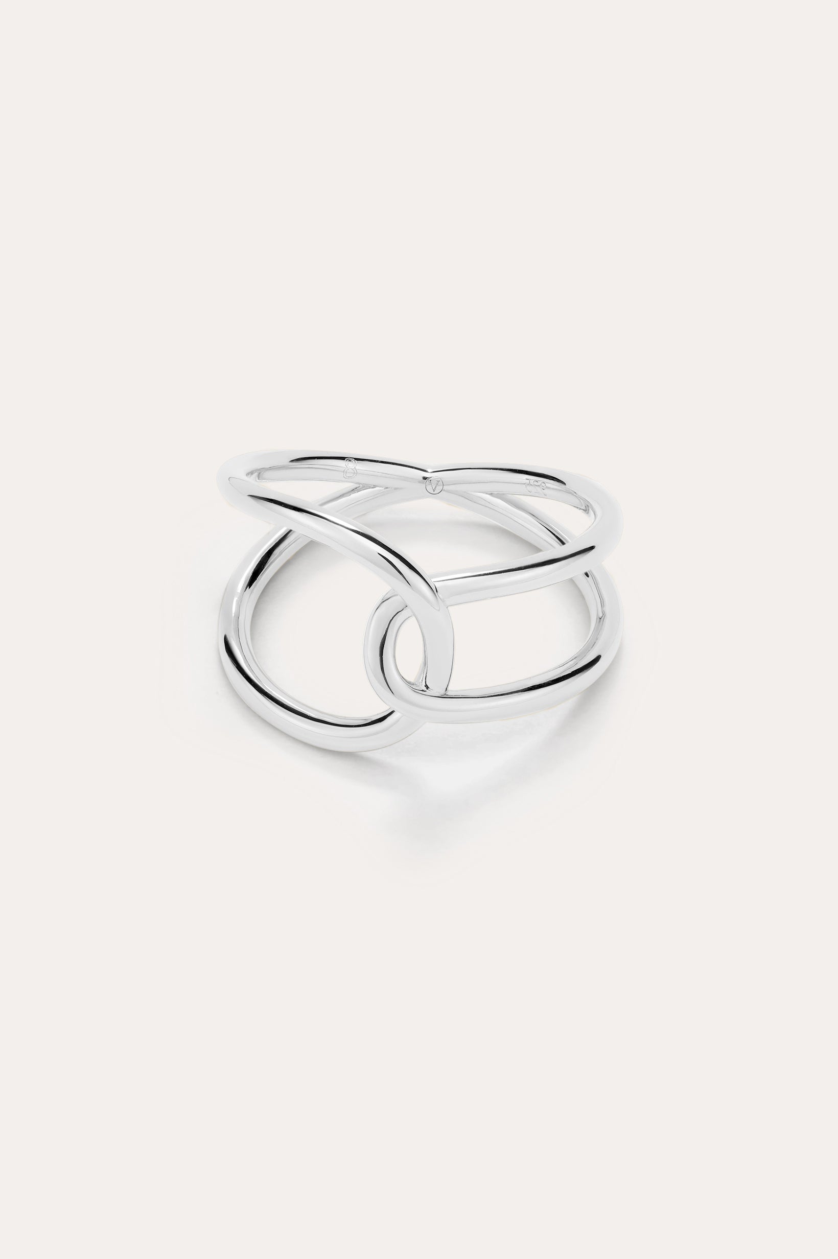 The Ayla Link Ring in Silver showcases a minimalist, modern design with two smooth, interlocking loops, set against a plain light background.