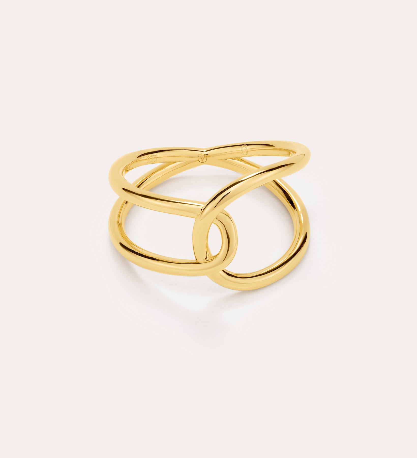 The Ayla Link Ring in Gold features a modern, intertwined double-band design plated in 18k gold, creating an elegant and minimalist loop pattern against a plain light background.