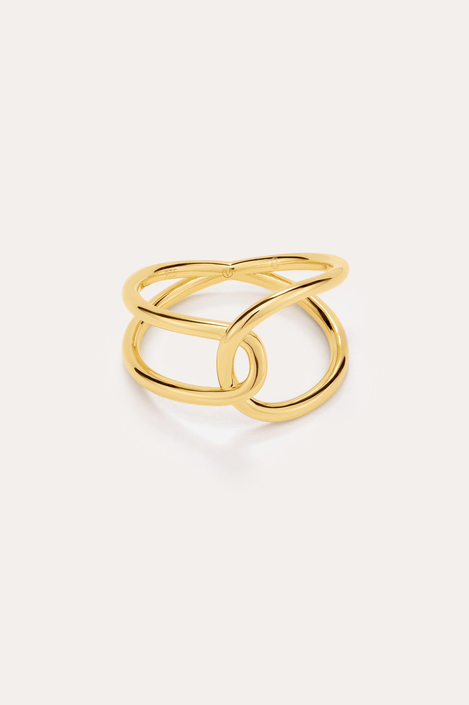 The Ayla Link Ring in Gold features a modern, intertwined double-band design plated in 18k gold, creating an elegant and minimalist loop pattern against a plain light background.