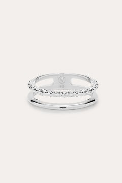 The Molten Double Band Ring in Sterling Silver features two parallel bands—one smooth, one twisted rope—connected at the sides. Stamped 925 and with a geometric logo, it's perfect for everyday wear on a light background.