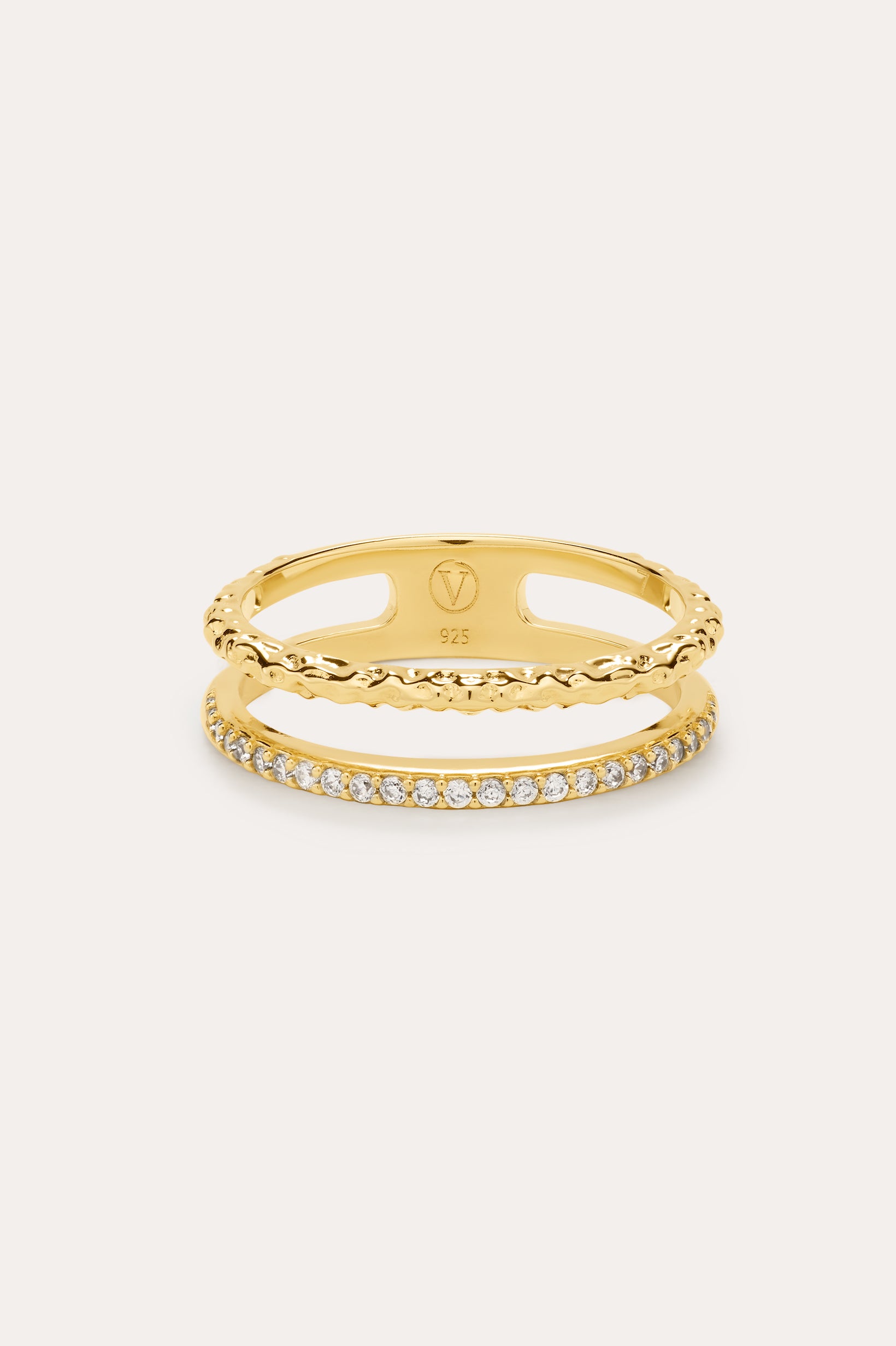 The Molten Crystal Double Band Ring in Gold features 18k gold plating, two connected bands—one with a twisted rope design and the other adorned with cubic zirconia—shown against a light background.