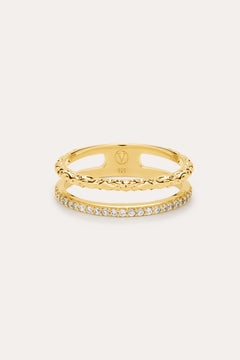 The Molten Crystal Double Band Ring in Gold features 18k gold plating, two connected bands—one with a twisted rope design and the other adorned with cubic zirconia—shown against a light background.