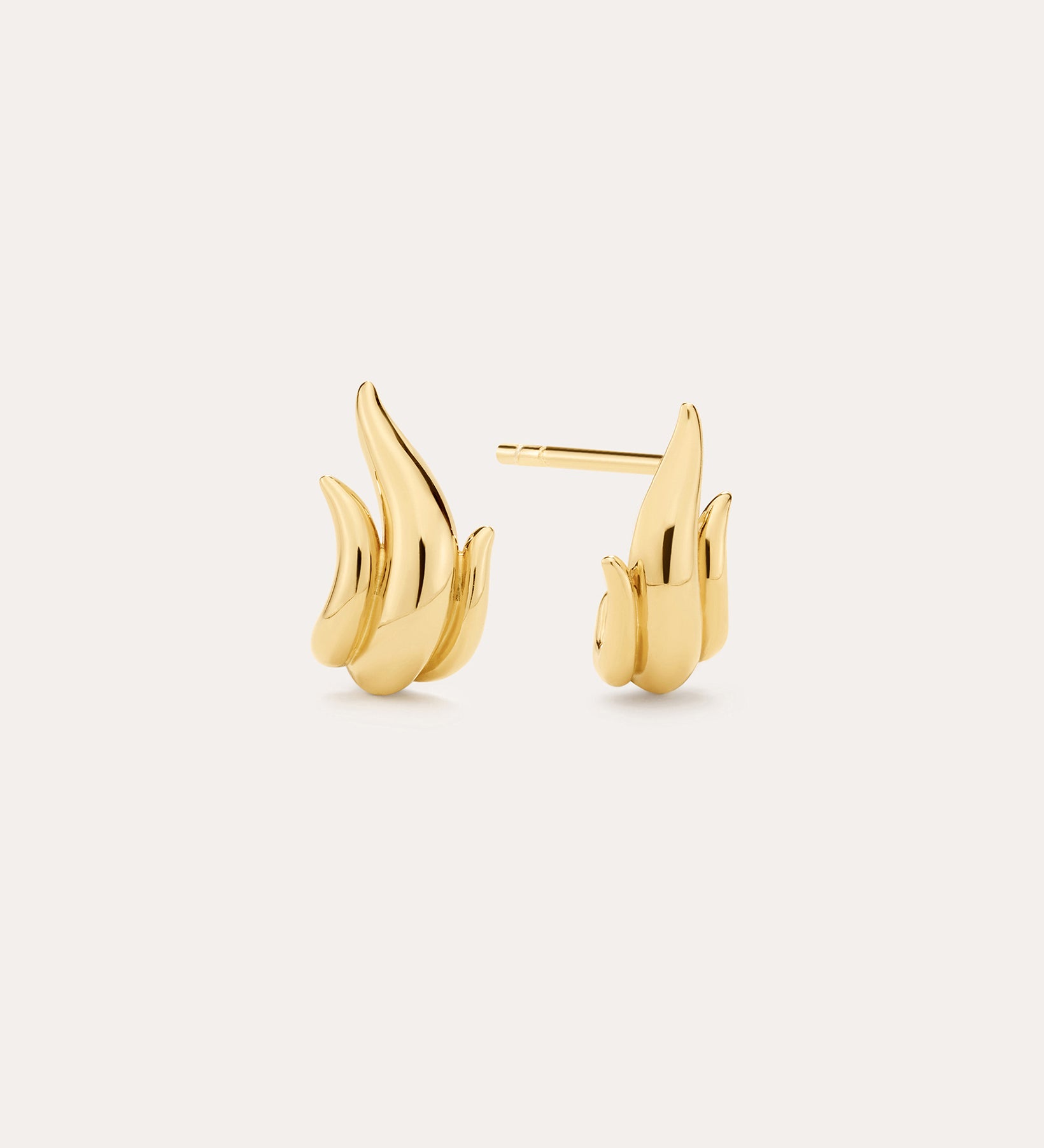 A pair of Flame Stud Earrings in Gold with a sculptural, flame-inspired design and 18k gold plated finish are shown on a light background—one facing forward and the other displaying the side and post.
