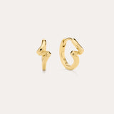 The image shows two small 18k gold plated stud earrings—one a lightning bolt, the other a looping squiggle—styled with Ribbon Twist Huggies in Gold, all set against an off-white background for a chic presentation.