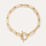 The Paperclip Toggle Bracelet in Gold, crafted in 18k gold plated finish with elongated oval links and a twisted toggle clasp, is shown against a plain light background.