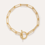 The Paperclip Toggle Bracelet in Gold, crafted in 18k gold plated finish with elongated oval links and a twisted toggle clasp, is shown against a plain light background.